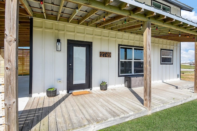 doorway to property featuring a deck and board and batten siding