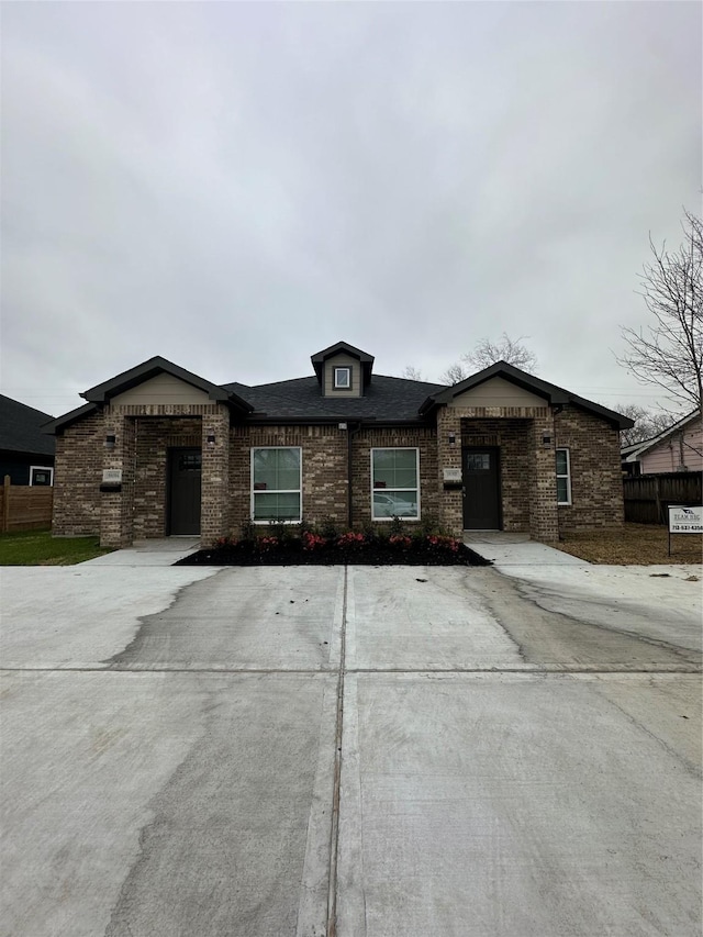 ranch-style home with brick siding and roof with shingles