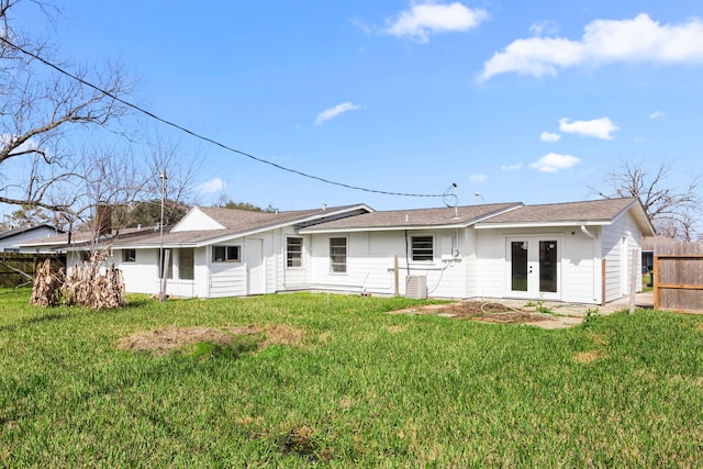 rear view of house with a yard, fence, and french doors