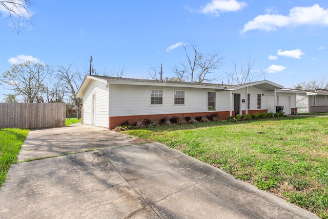 ranch-style house featuring an attached garage, brick siding, a front yard, and fence