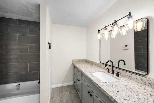 full bathroom featuring baseboards, shower / bathing tub combination, a textured ceiling, and vanity