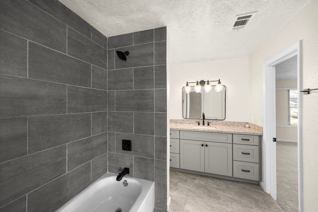 full bathroom with visible vents, bathing tub / shower combination, vanity, and a textured ceiling