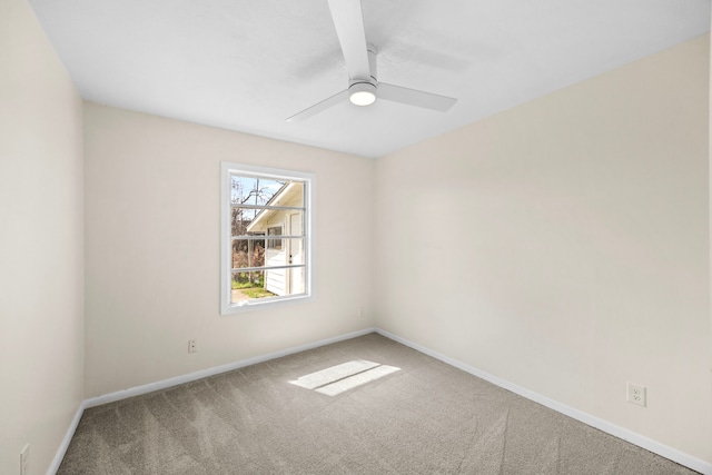 spare room featuring a ceiling fan, carpet, and baseboards