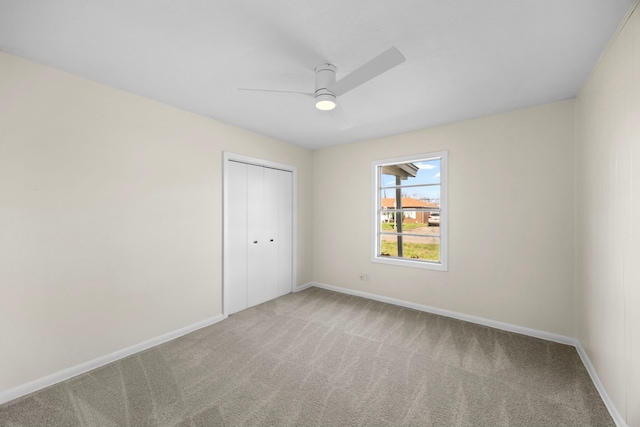 spare room featuring ceiling fan, carpet floors, and baseboards