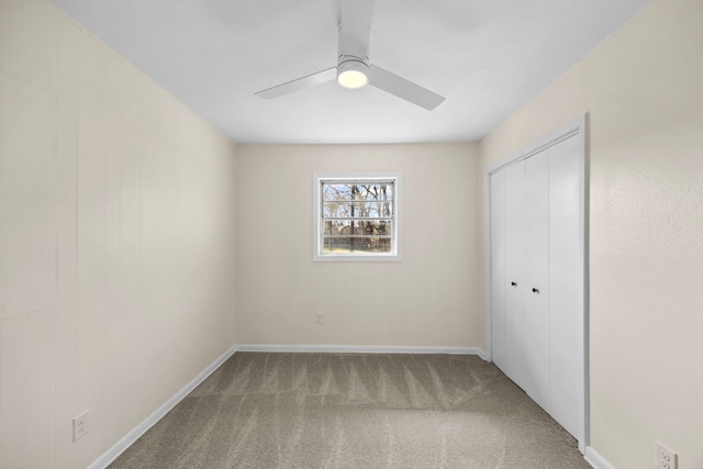 unfurnished bedroom featuring a closet, carpet flooring, a ceiling fan, and baseboards