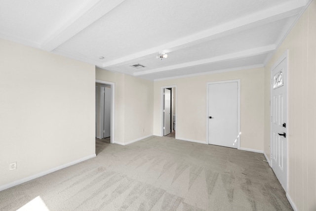 unfurnished room featuring beam ceiling, visible vents, light carpet, and baseboards