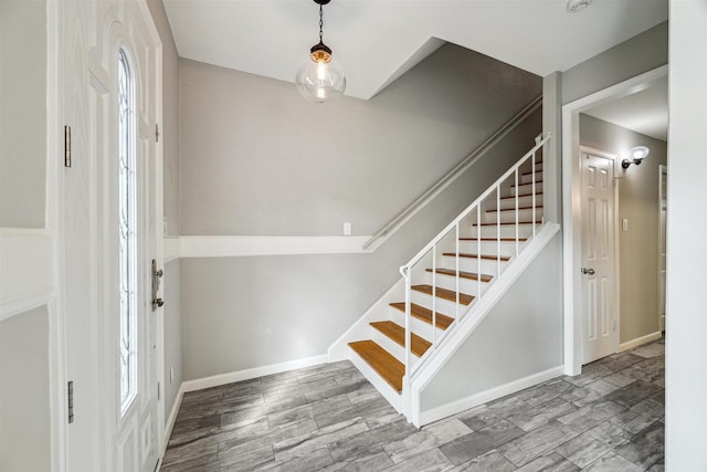 foyer featuring stairway, wood finish floors, and baseboards