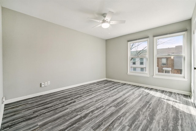 unfurnished room with dark wood-style floors, baseboards, and a ceiling fan