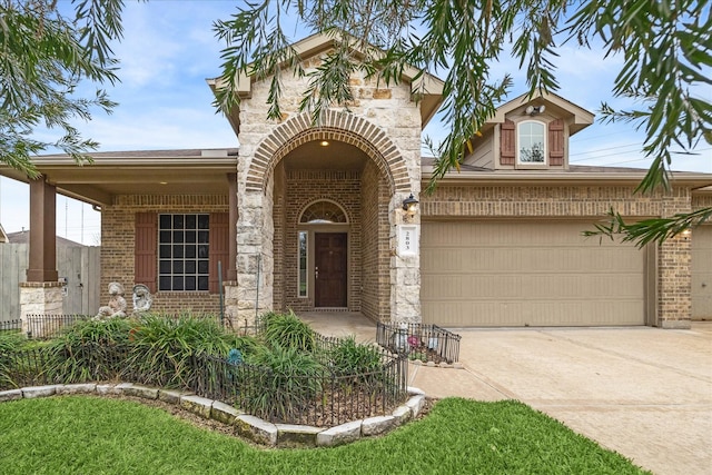 view of front of property with a garage, stone siding, brick siding, and driveway