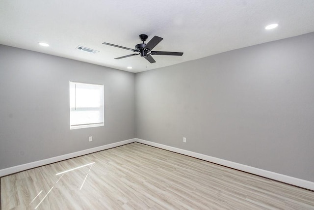 empty room with recessed lighting, light wood-type flooring, visible vents, and baseboards