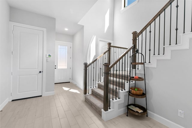 foyer featuring recessed lighting, stairway, light wood-type flooring, and baseboards