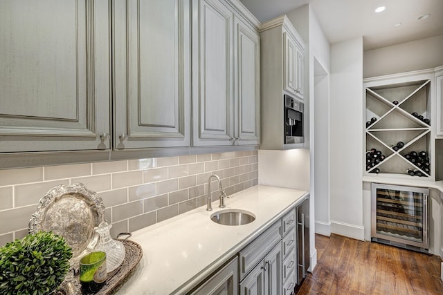 interior space with decorative backsplash, wine cooler, dark wood-type flooring, a sink, and recessed lighting