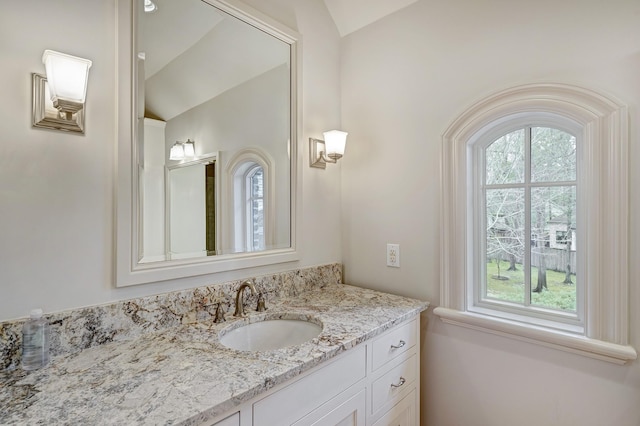 bathroom featuring vaulted ceiling and vanity