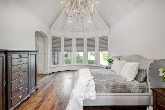 bedroom with beam ceiling, high vaulted ceiling, arched walkways, and wood finished floors