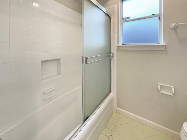 bathroom featuring bath / shower combo with glass door, tile patterned flooring, toilet, and baseboards