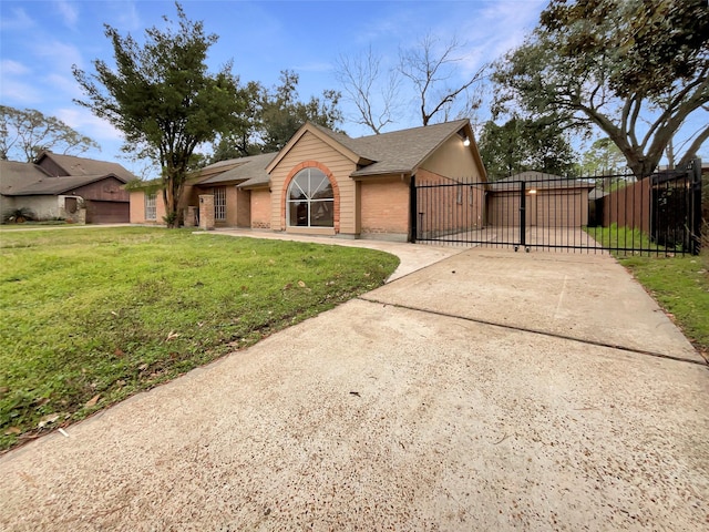 view of front of house with brick siding, a shingled roof, fence, driveway, and a front lawn