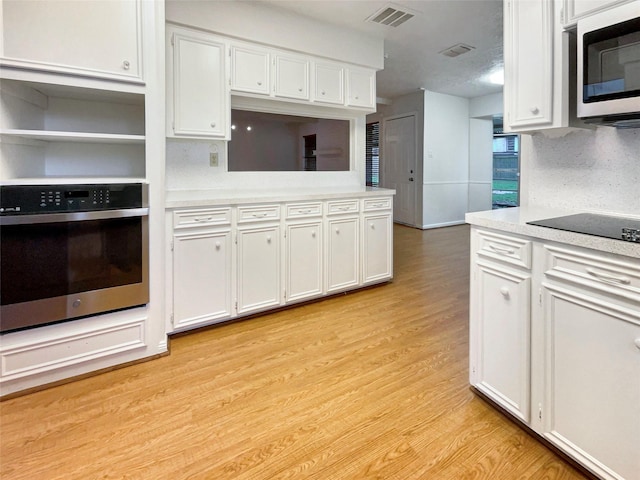 kitchen with white cabinetry, visible vents, appliances with stainless steel finishes, and light countertops