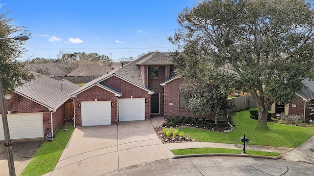 view of front facade featuring brick siding, fence, a front yard, a garage, and driveway