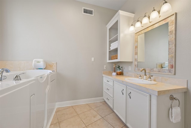 bathroom featuring vanity, visible vents, baseboards, tile patterned flooring, and a garden tub