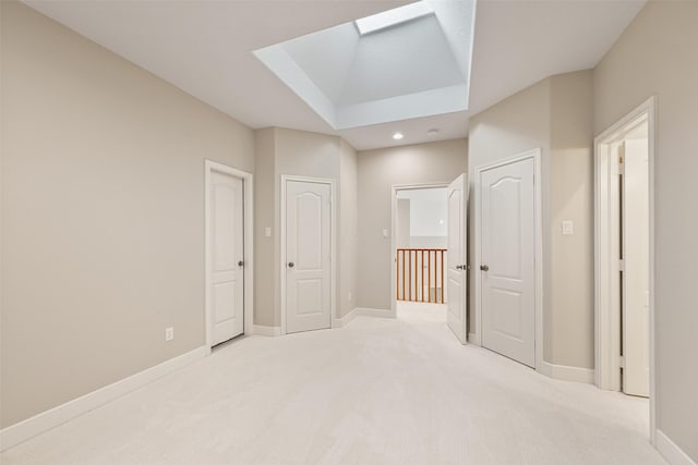interior space with recessed lighting, baseboards, light carpet, and a skylight