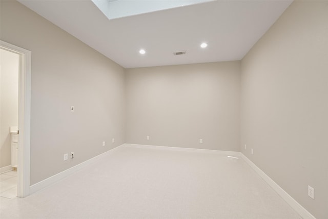unfurnished room featuring a skylight, recessed lighting, visible vents, and baseboards