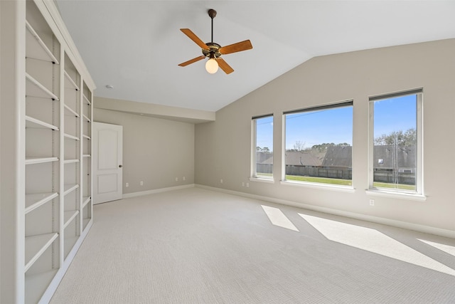 carpeted empty room with baseboards, ceiling fan, and vaulted ceiling