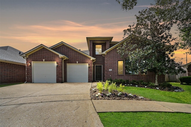 view of front of property featuring brick siding, a lawn, driveway, and a garage