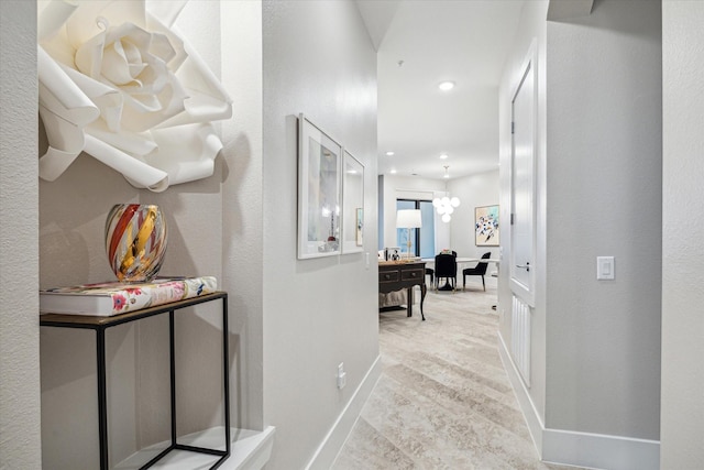 hall with light wood finished floors, baseboards, a notable chandelier, and recessed lighting