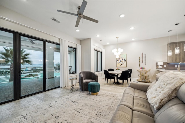 living area featuring ceiling fan with notable chandelier, visible vents, and recessed lighting