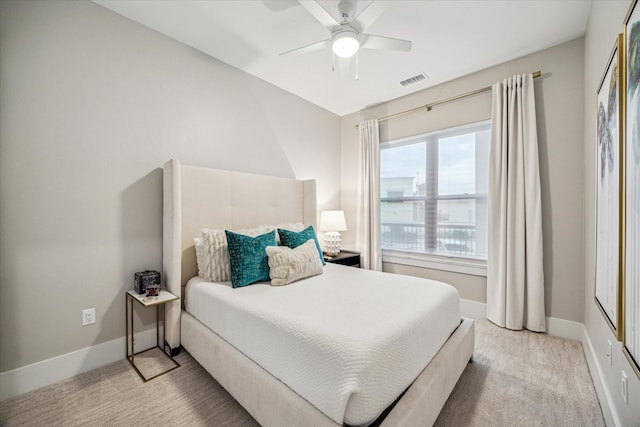 bedroom featuring baseboards, ceiling fan, visible vents, and light colored carpet