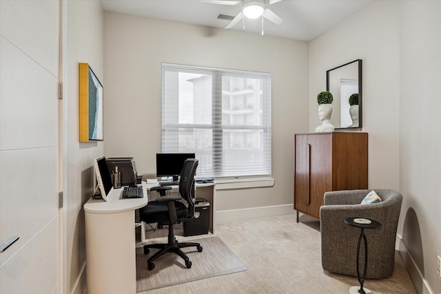 home office with a ceiling fan, visible vents, light carpet, and baseboards