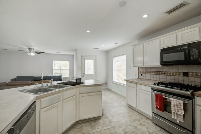 kitchen featuring visible vents, appliances with stainless steel finishes, open floor plan, light countertops, and a sink