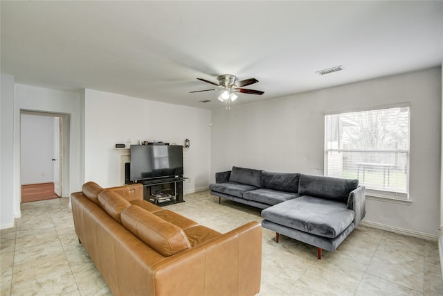 living room with visible vents, ceiling fan, and baseboards