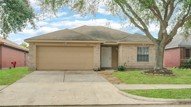 ranch-style home featuring a front yard, concrete driveway, brick siding, and an attached garage