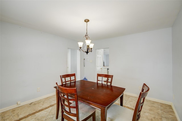 dining area with a chandelier and baseboards