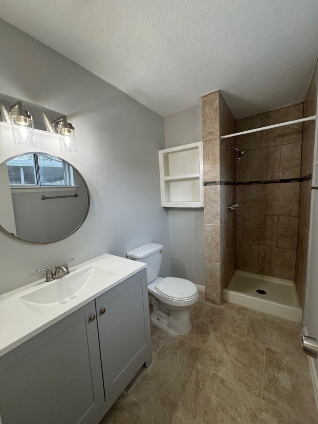 9809 Richmond Ave Unit J1, Houston, TX 77042 - full bathroom featuring vanity, a textured ceiling, a tile shower, and tile patterned floors