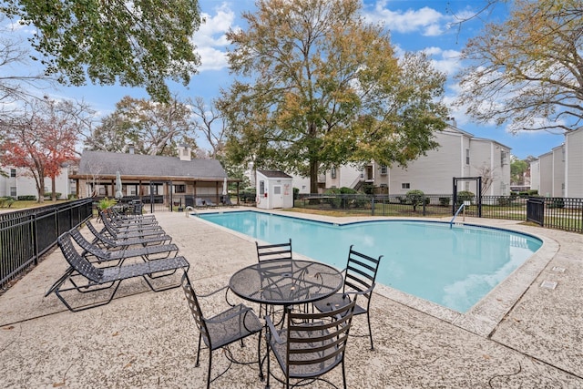 9809 Richmond Ave Unit J1, Houston, TX 77042 - community pool featuring a patio area, a residential view, and an outbuilding