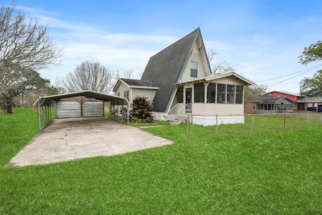 exterior space with a detached carport, a sunroom, a lawn, and driveway