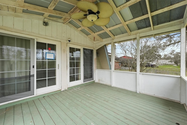 unfurnished sunroom with a ceiling fan and vaulted ceiling