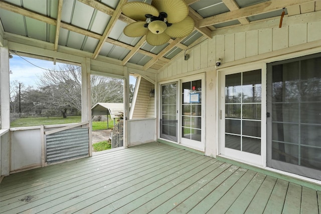 unfurnished sunroom with a ceiling fan and lofted ceiling with beams