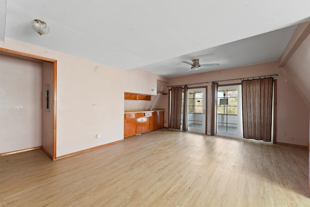 unfurnished living room featuring a ceiling fan, light wood-type flooring, and baseboards