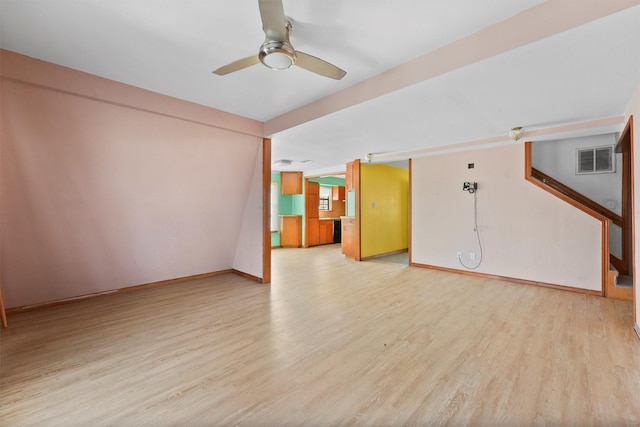 interior space featuring light wood-style flooring, visible vents, baseboards, stairs, and a ceiling fan