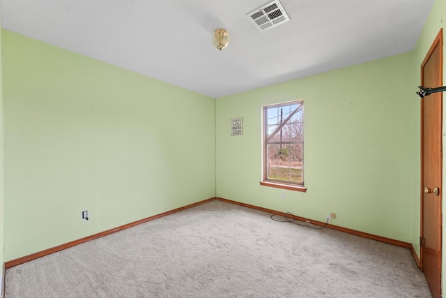 empty room with carpet floors, baseboards, and visible vents