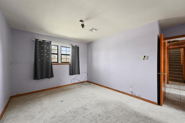 unfurnished room featuring visible vents, light carpet, stairway, and baseboards