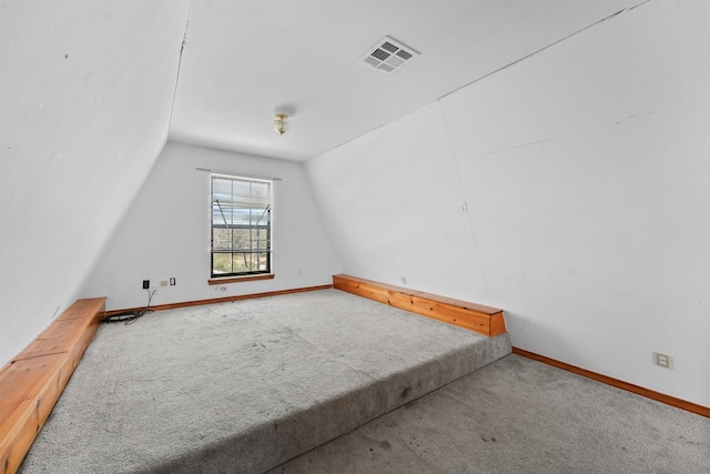 additional living space featuring vaulted ceiling, carpet flooring, visible vents, and baseboards