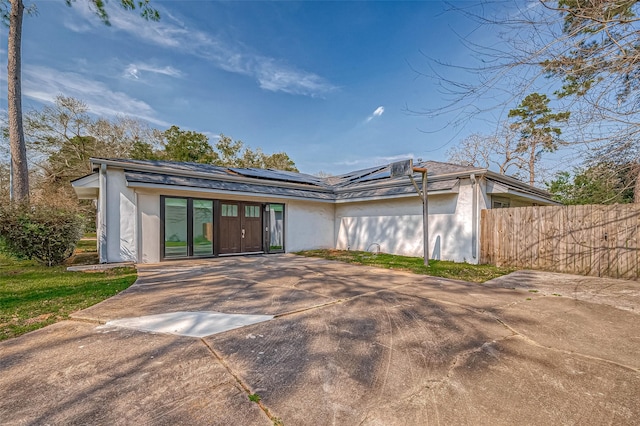 mid-century modern home with fence and stucco siding