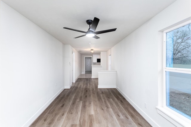 spare room featuring ceiling fan, wood finished floors, and baseboards