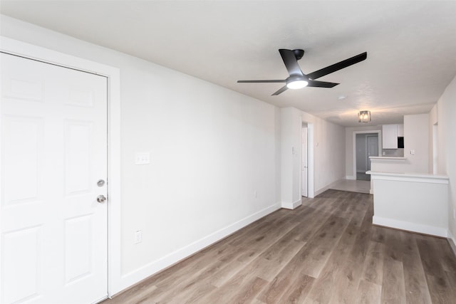 unfurnished living room featuring light wood-type flooring, ceiling fan, and baseboards