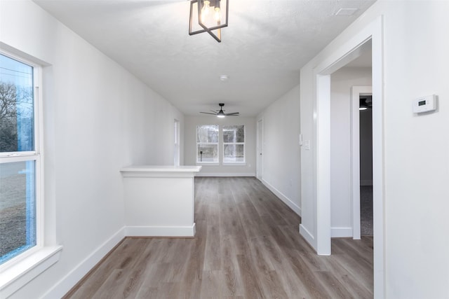 hallway featuring light wood-style floors and baseboards