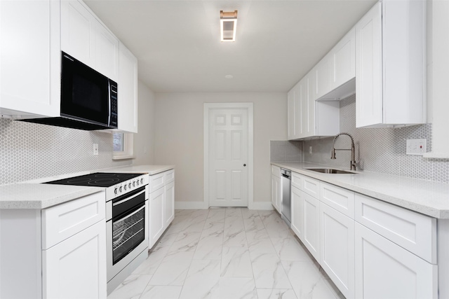 kitchen with marble finish floor, light countertops, stove, a sink, and black microwave